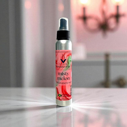 Misty Melon fragrance mist bottle on a reflective surface with a blurred background