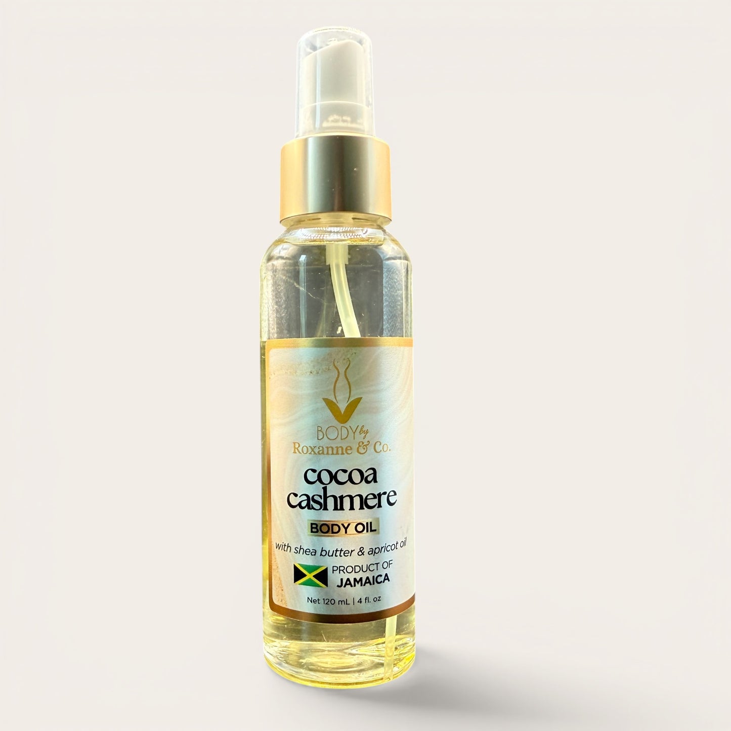 Bottle of cocoa cashmere body oil on a light gray background