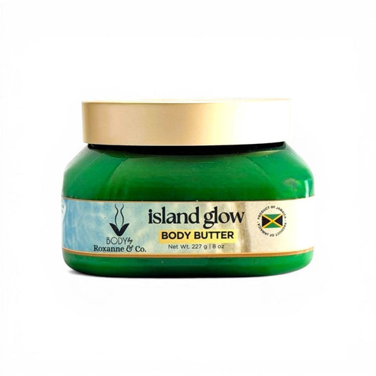 BODY By Roxanne & Co. Island Glow Body Butter in a green jar with a gold lid. Features pistachio, salted caramel, sandalwood, vanilla, and sea salt.