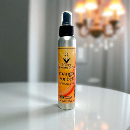Mango sorbet fragrance mist bottle on a reflective surface with blurred background