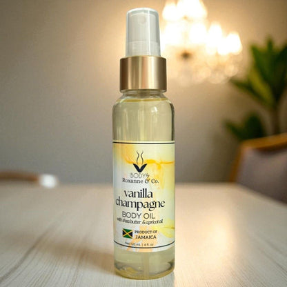 Bottle of Vanilla Champagne body oil on a wooden surface with a blurred background