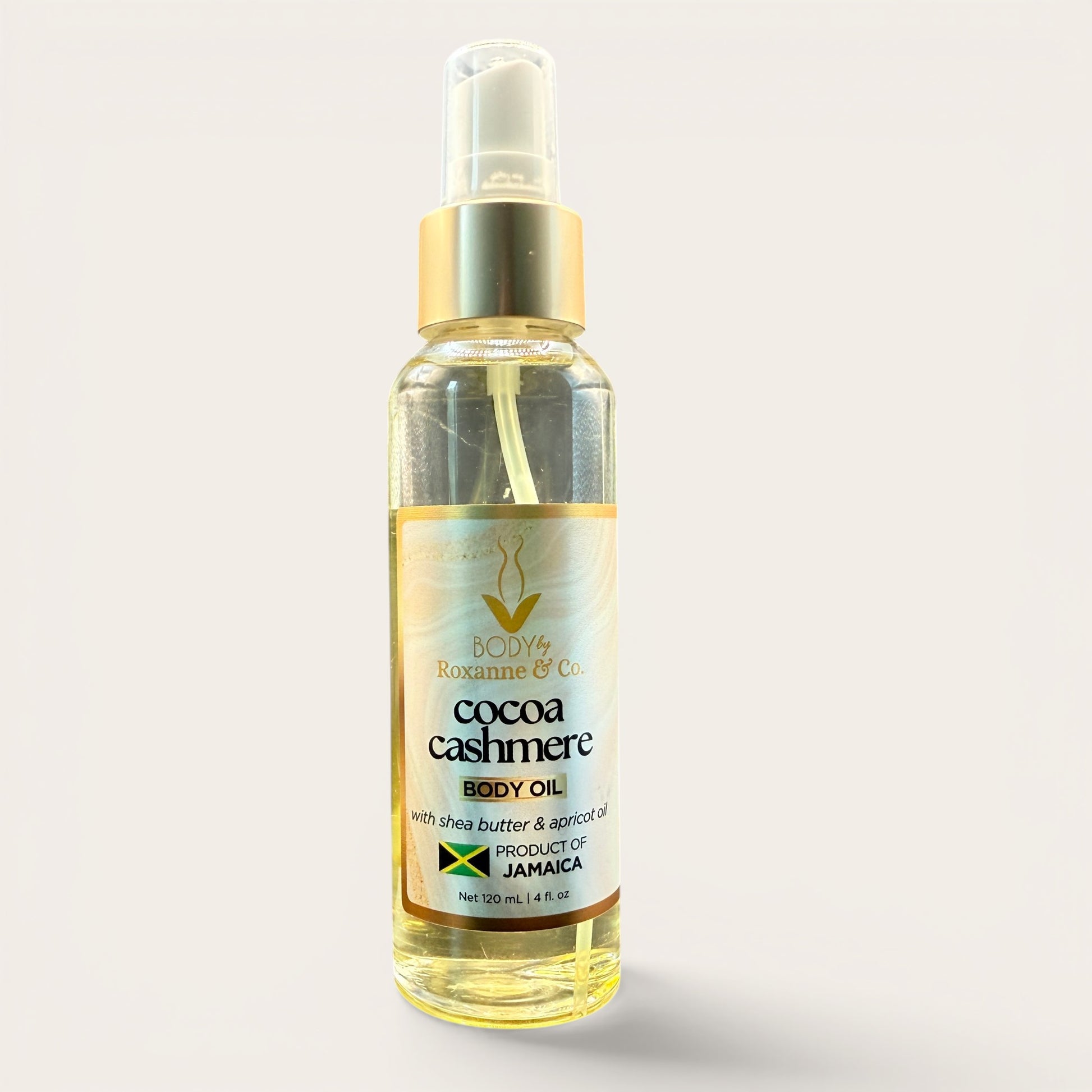Bottle of cocoa cashmere body oil on a light gray background