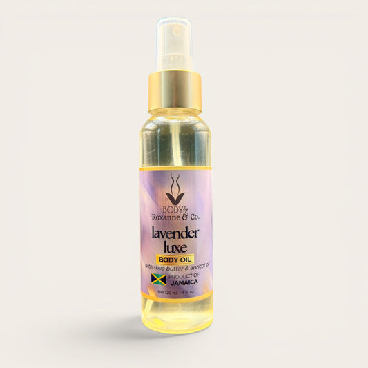 Bottle of lavender body oil with a gold spray nozzle on a light gray background