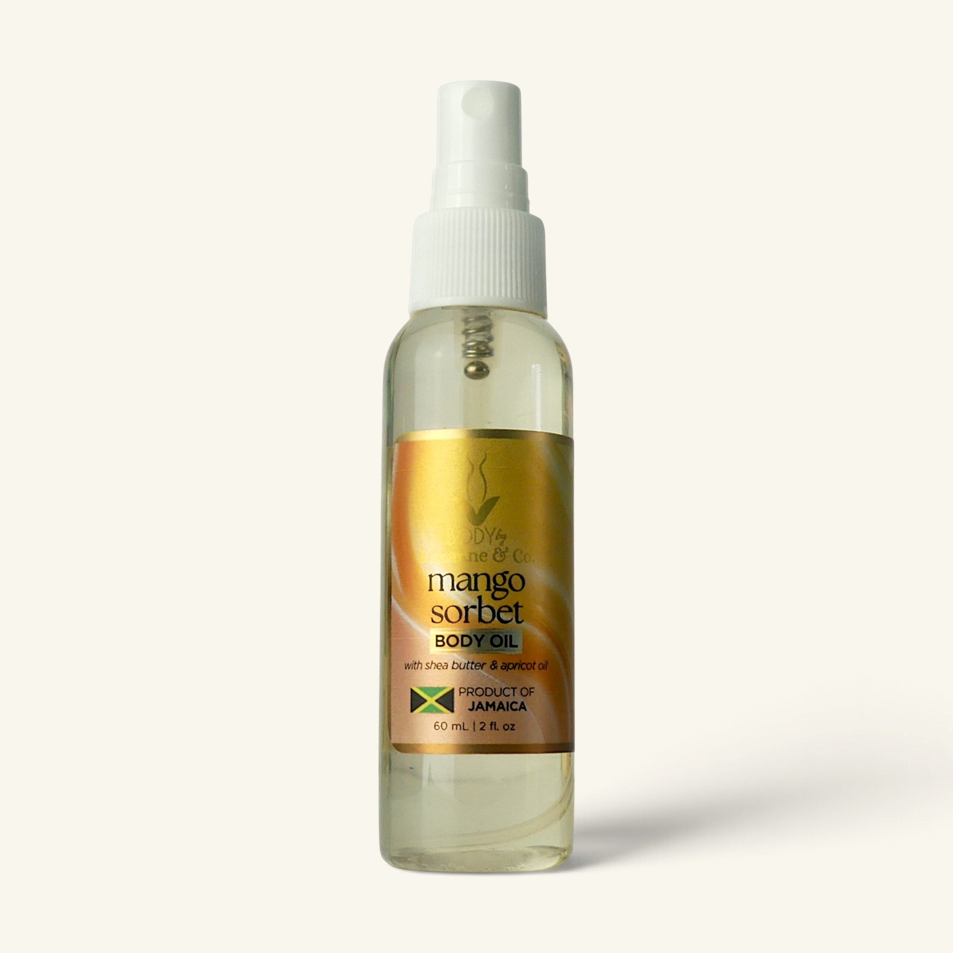 A clear plastic spray bottle of Mango Sorbet Body Oil with a white pump dispenser and a gold label, set against a solid off-white background.