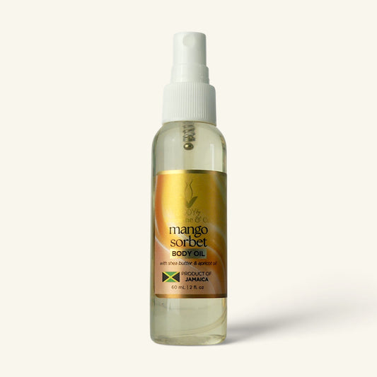 A clear plastic spray bottle of Mango Sorbet Body Oil with a white pump dispenser and a gold label, set against a solid off-white background.