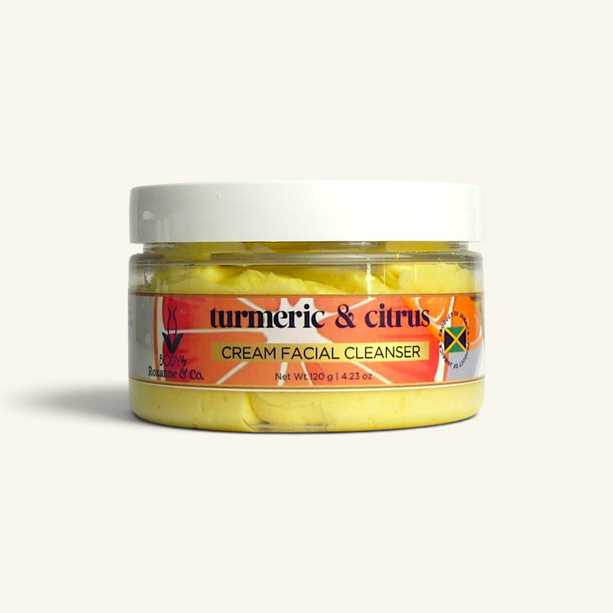 A jar of Turmeric & Citrus Cream Facial Cleanser by Jamaica & Co. The product is shown in a clear plastic jar with a white lid, revealing the yellow cleanser inside.